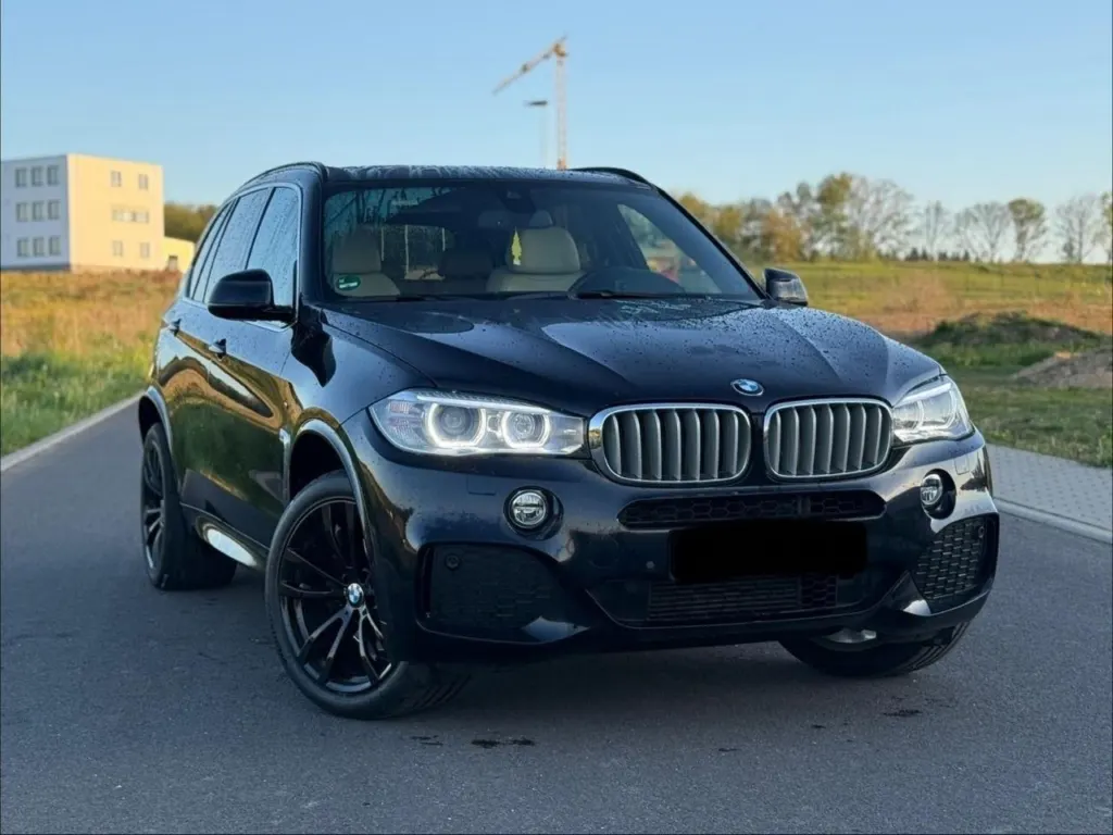 Schwarzer BMW X5 M-Paket auf einer Straße im Abendlicht
