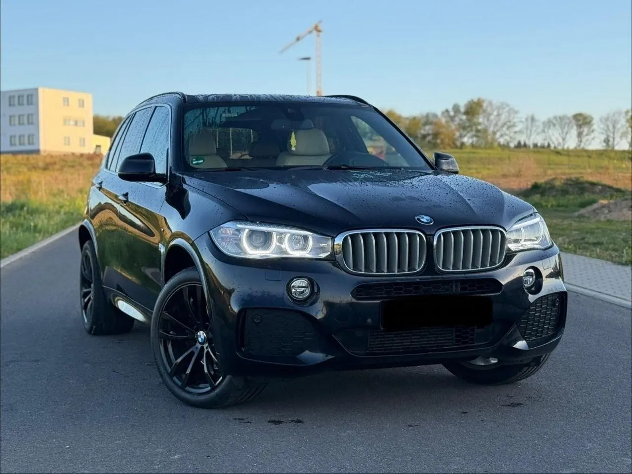 Schwarzer BMW X5 M-Paket auf einer Straße im Abendlicht