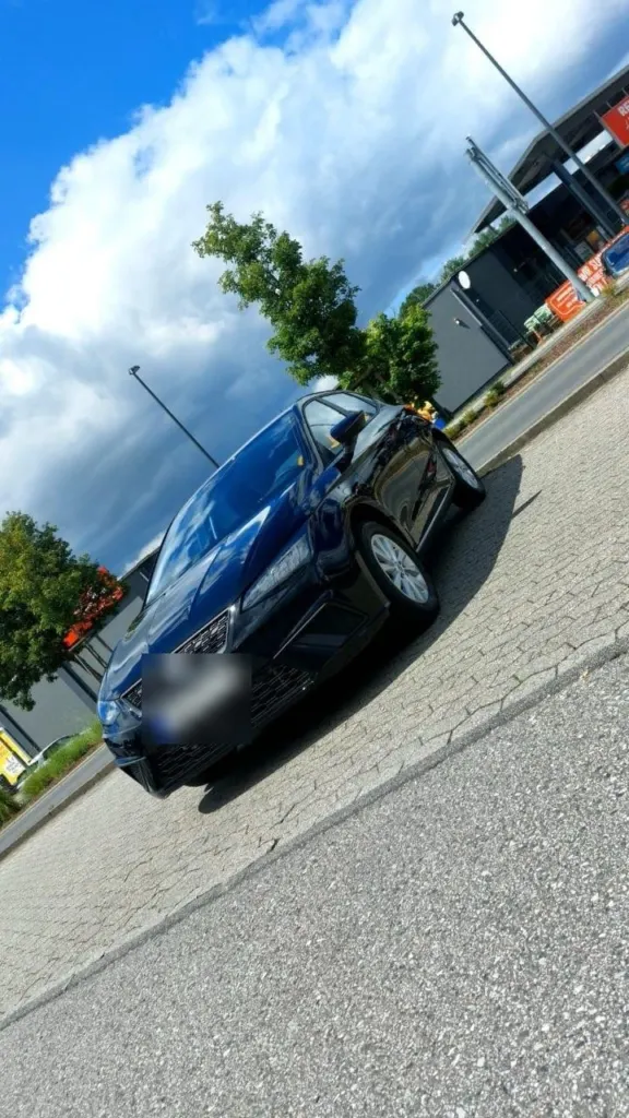 Dunkelblauer Seat Ibiza auf einem Parkplatz unter Wolkenhimmel